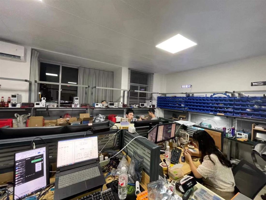 Our engineers at the debug bench in Shenzhen with instruments, parts bins and boards under test